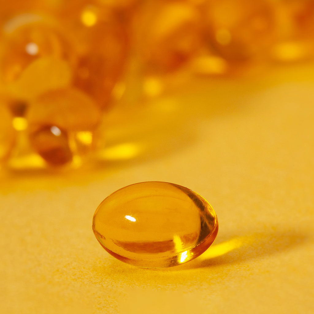 A photo of an amber capsule against an amber-coloured background.