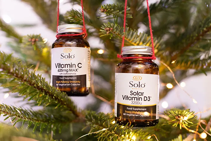 Solo Nutrition Vitamin C & Vitamin D bottles handing from a Christmas Tree